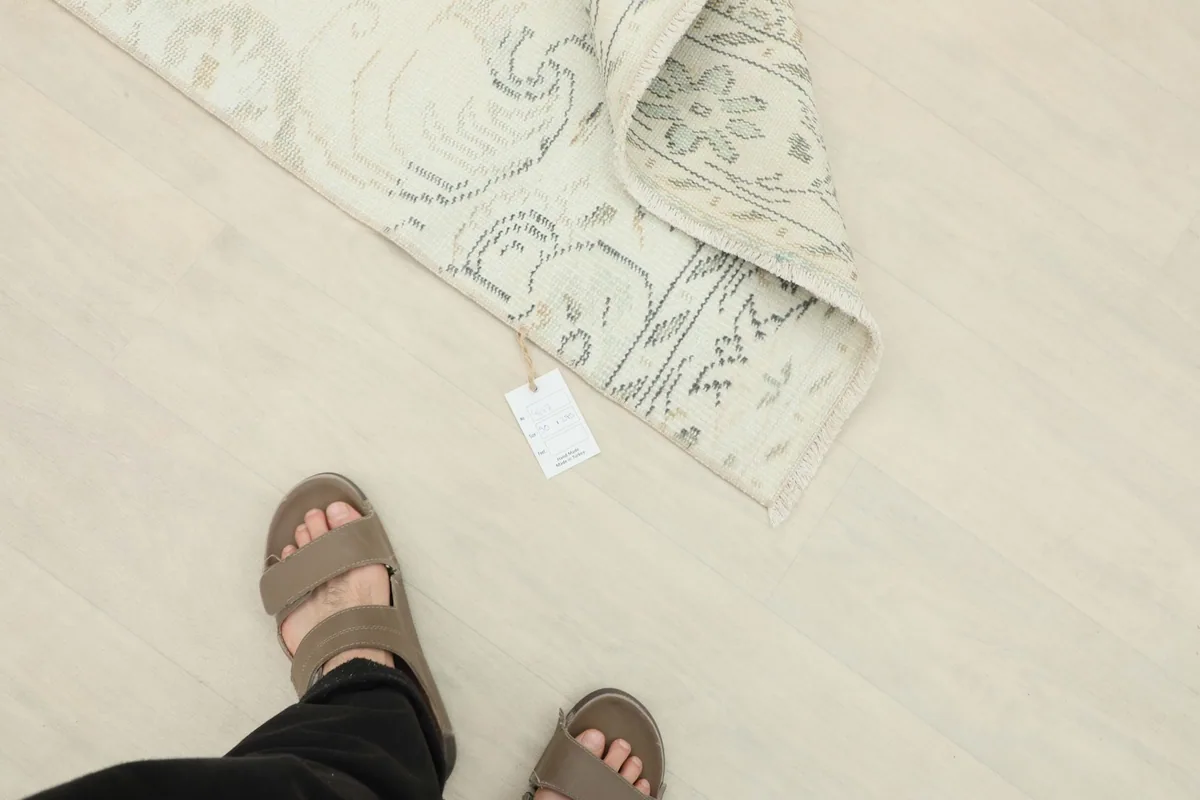 Person's feet next to the folded rug, indicating its size and scale