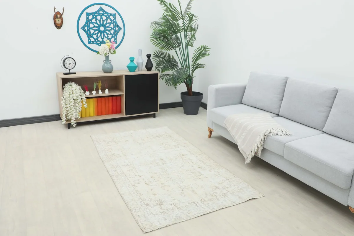 Vintage ivory beige rug placed in a living room setting with a sofa and decor