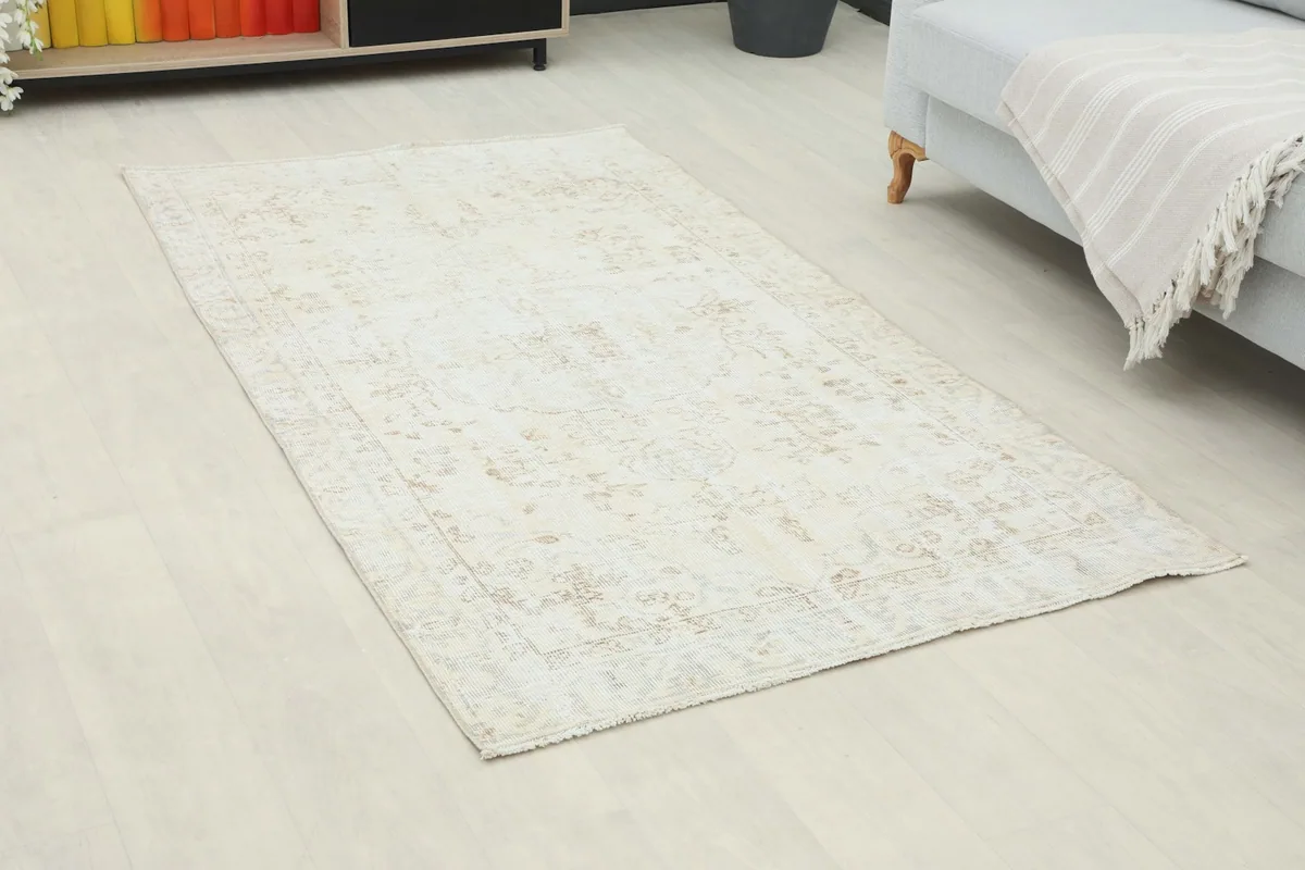Angle view of the ivory and beige rug in a room, showing its placement on the floor