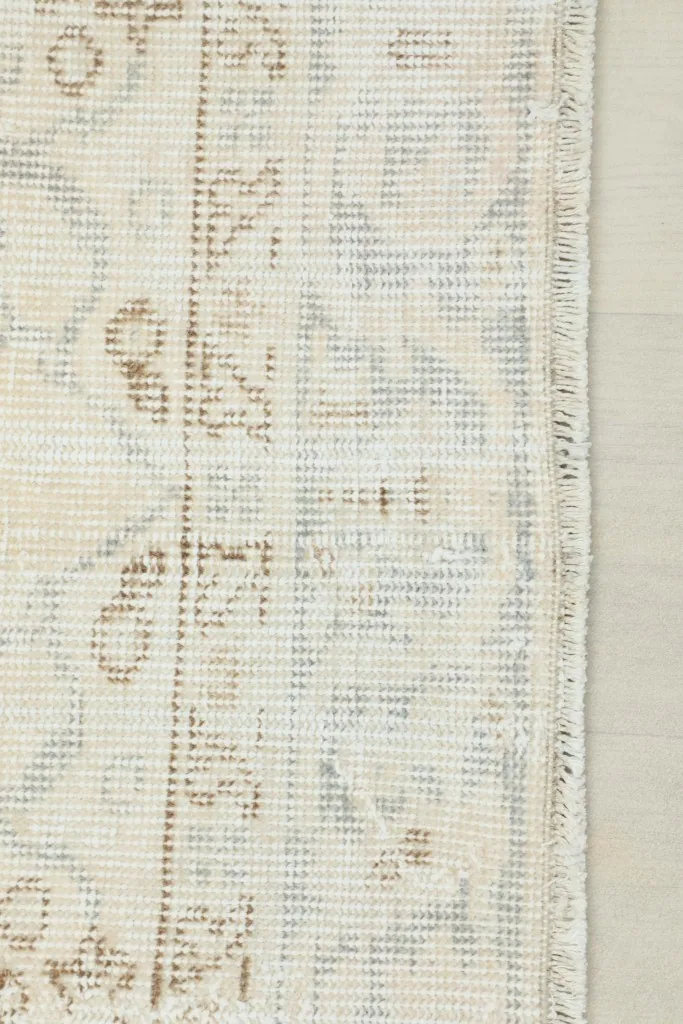 Close-up showing the low pile and subtle blue threads in the vintage rug