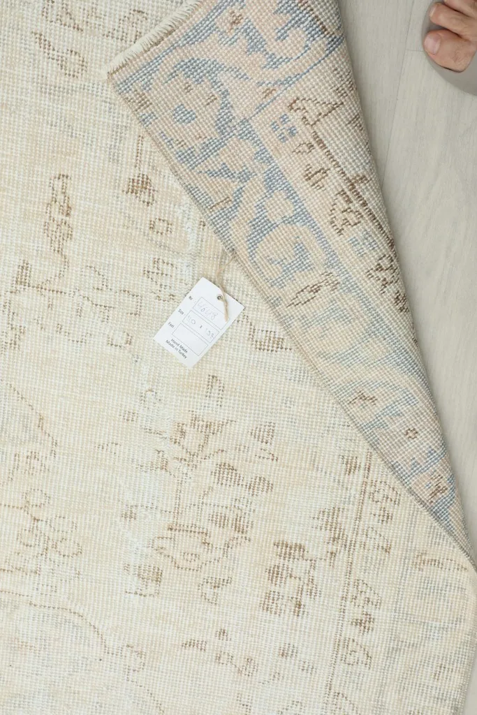 View of the rug's back and foundation with a product tag visible