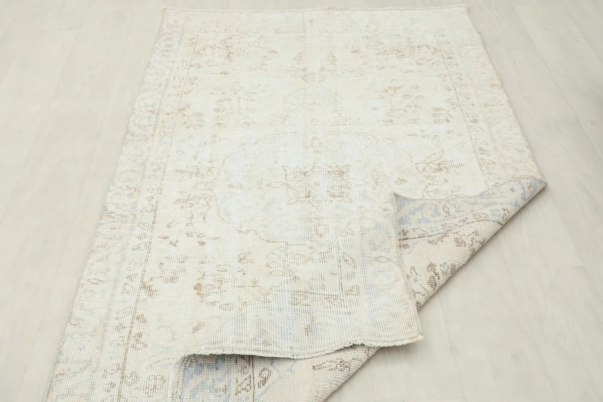 Rug with a corner folded over, displaying the underside and overall texture