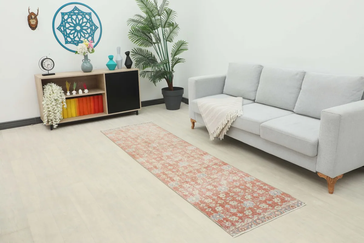 Runner rug placed in a modern living room setting, showing its scale next to a sofa