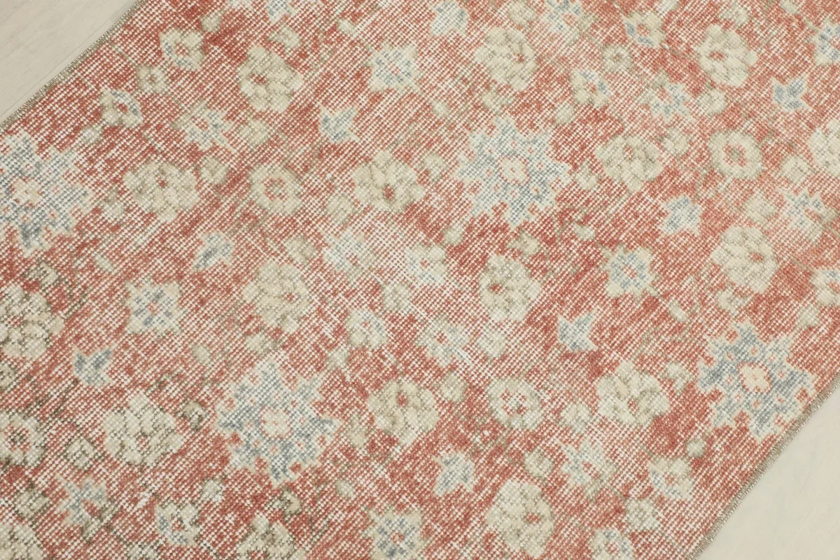 Overhead close-up of the distressed rust field and the beige and gray floral pattern
