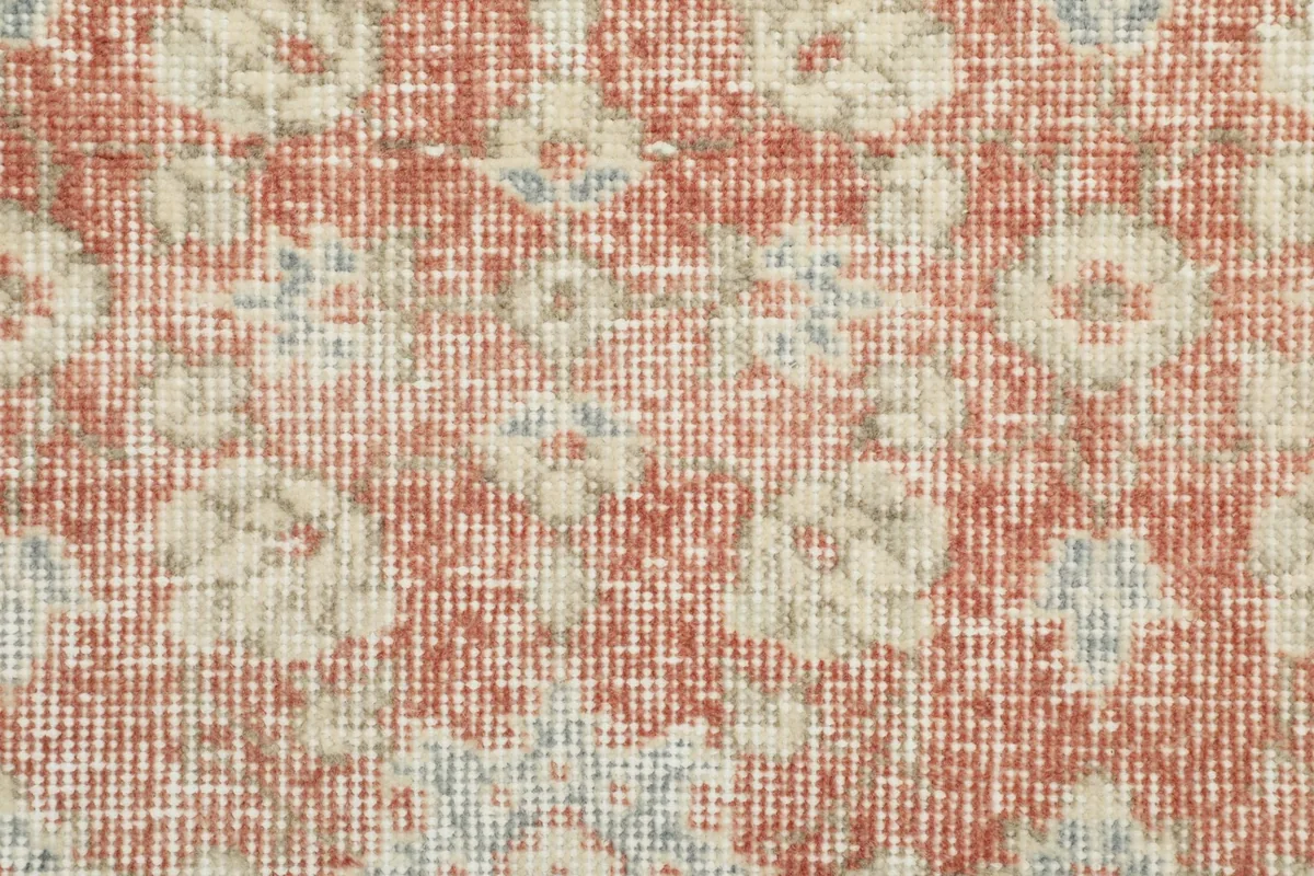 Extreme close-up showing the low wool pile and hand-knotted texture of the rug