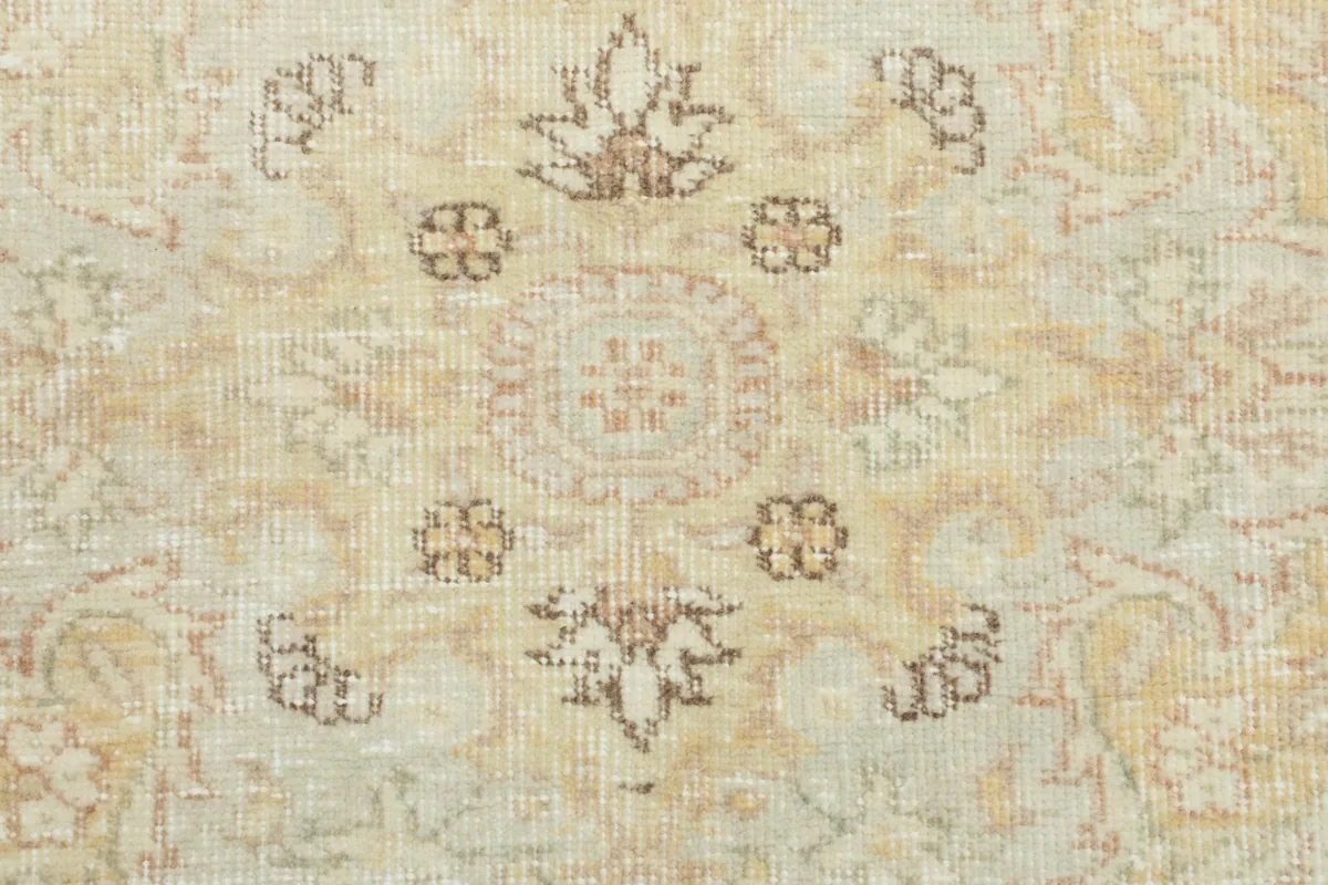 Close-up of the wool pile texture and intricate floral motifs within the medallion of the vintage rug.