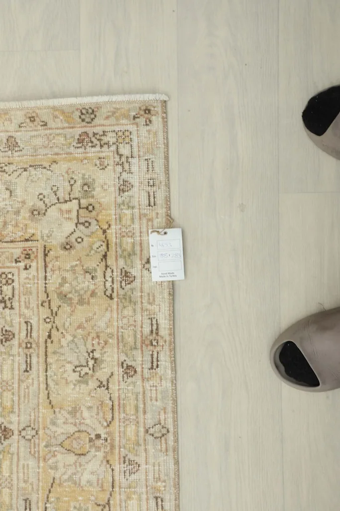 Overhead view showing the rug's label and a person's feet, indicating the scale and texture.