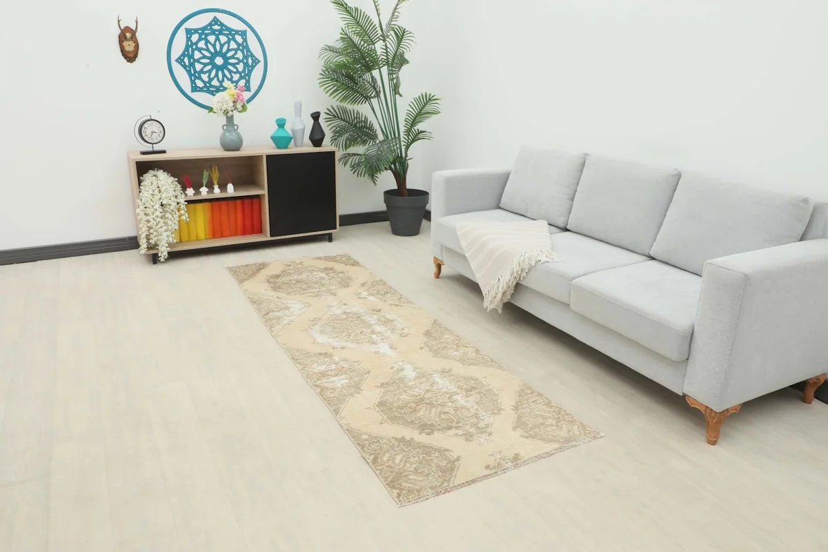 Runner rug placed in a living room setting next to a sofa and cabinet