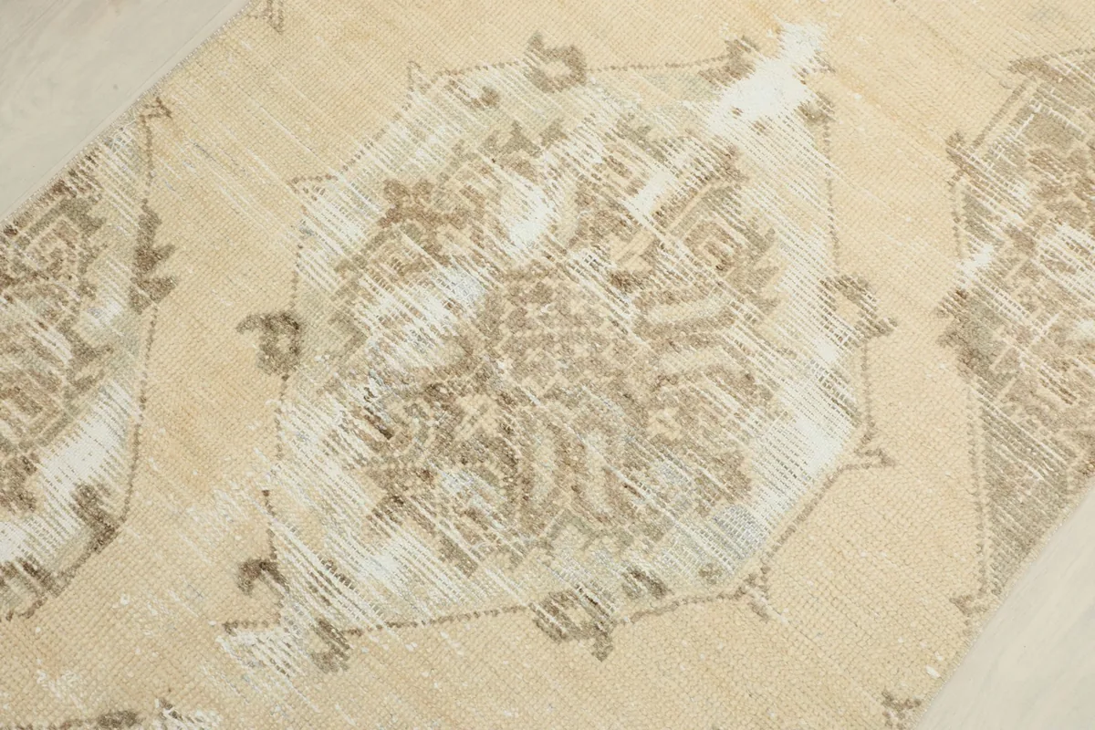 Detailed view of a central geometric motif, revealing the distressed wool pile