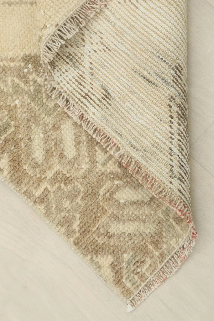 View of the back of the rug, showing the cotton foundation and knotting structure