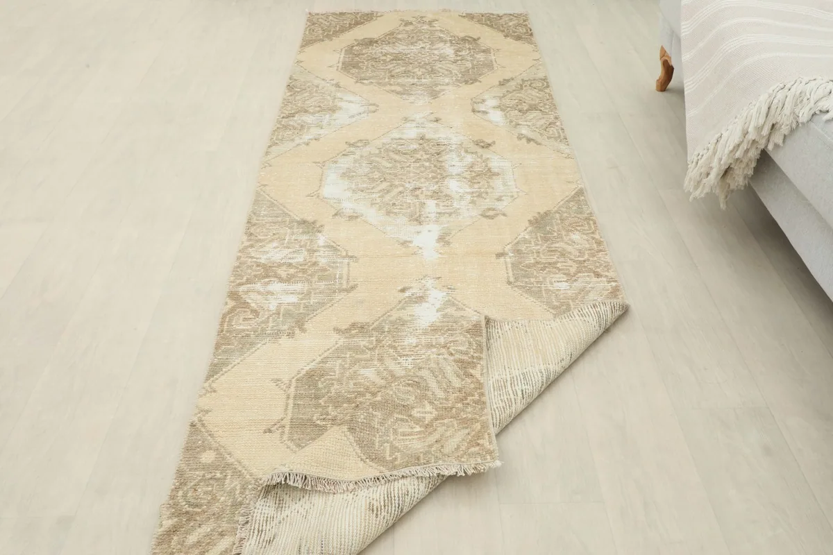 Runner rug partially folded, displaying both the pile and the reverse side