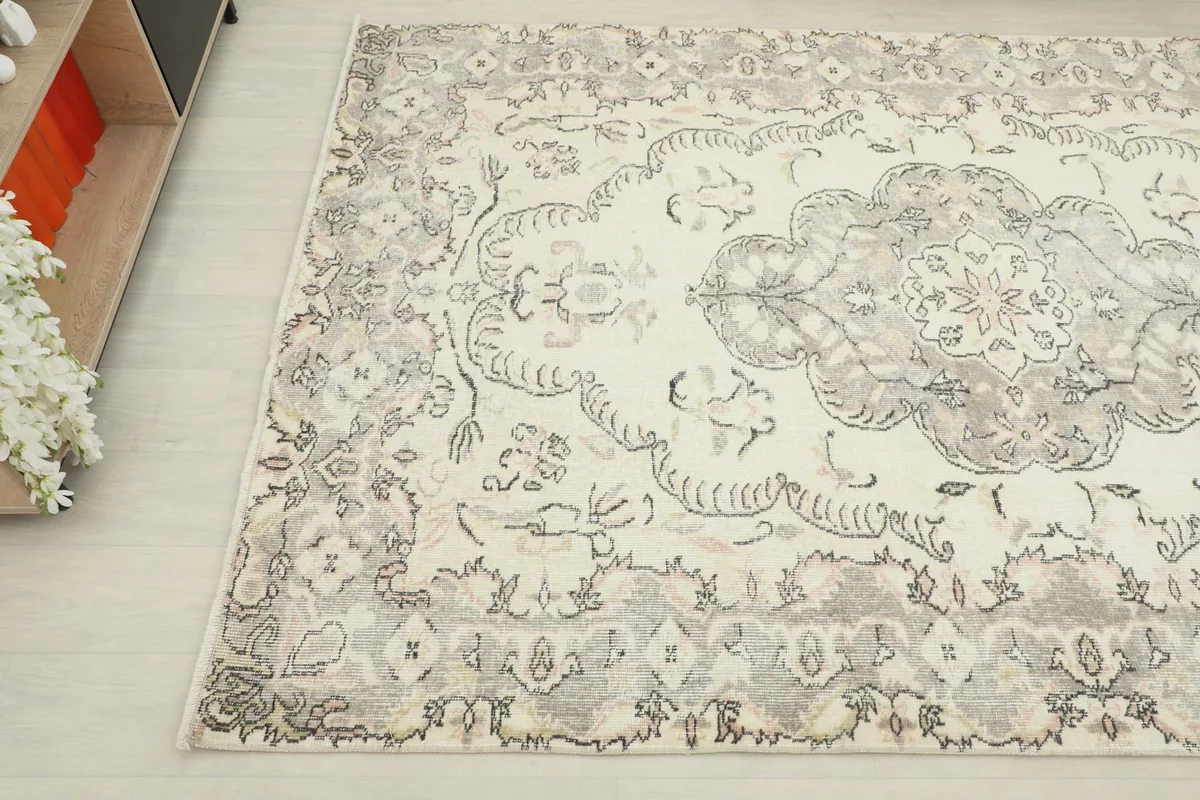Detailed angle of the rug's border and central medallion with faded gray tones