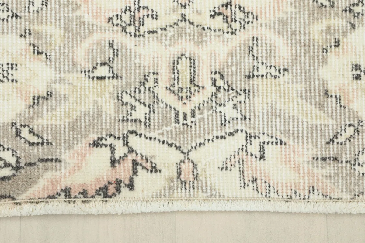 Close-up of the rug's border and fringe, showing the low pile and weave