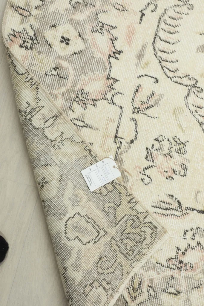 Reverse side of the hand-knotted rug, revealing the cotton foundation and weave