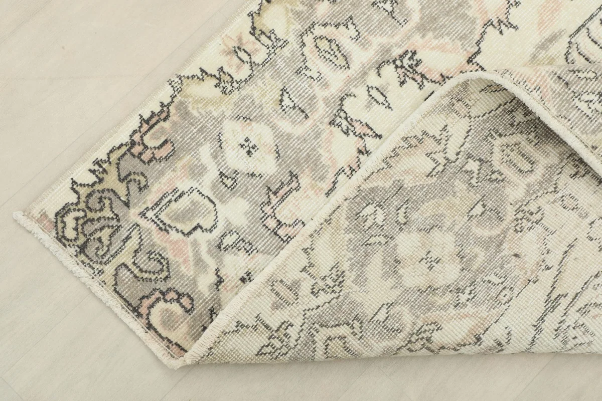 Corner of the hand-knotted rug folded back to show the reverse side and detail