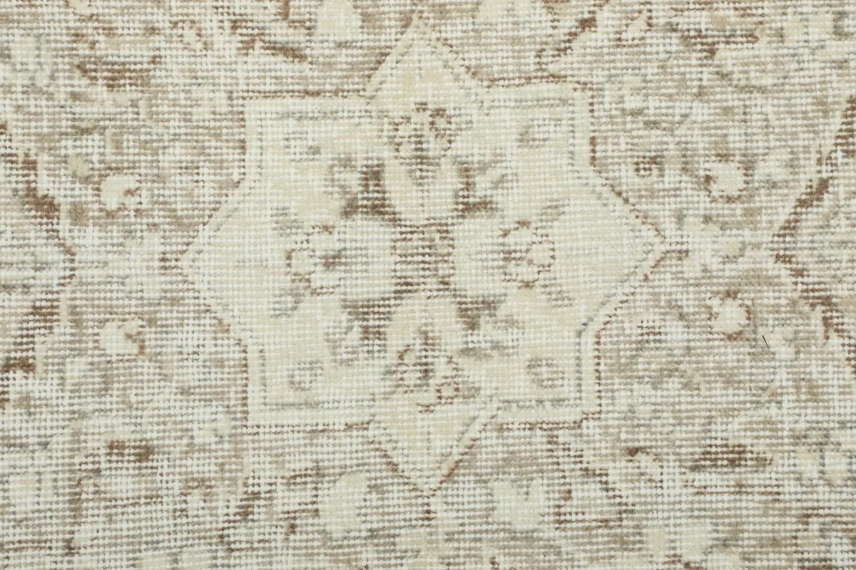 Close-up detail of the hand-knotted wool pile, showing the texture and muted beige tones.