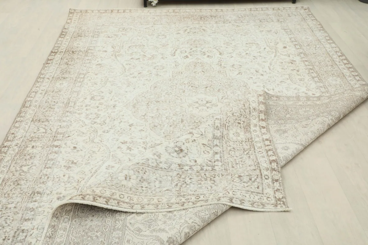 Partial view of the rug with a corner folded over, showing the back and the full pattern.
