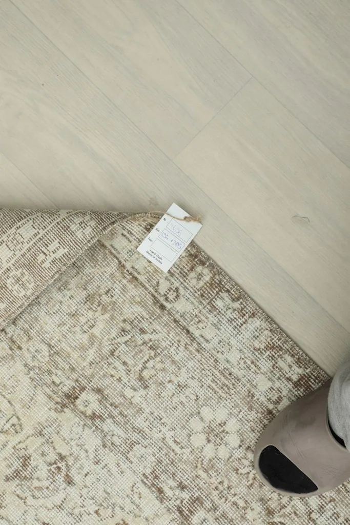Close-up of the rug's corner with the product tag, indicating its origin and materials.