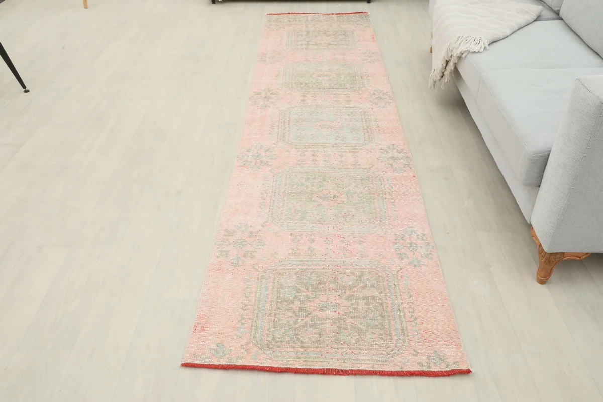 Overhead view of the rose and green runner rug laid out in a room, offering a full perspective.