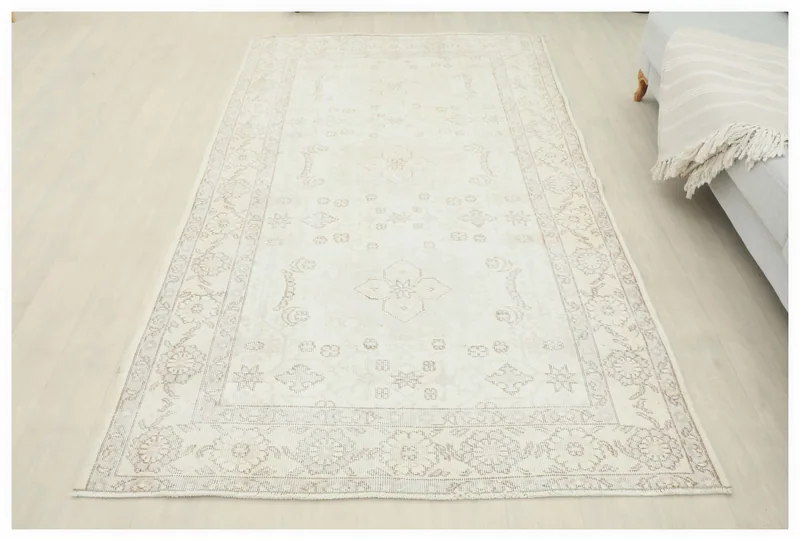 Full overhead view of the 4'11" x 8'1" ivory and beige vintage Anatolian rug on a white background.