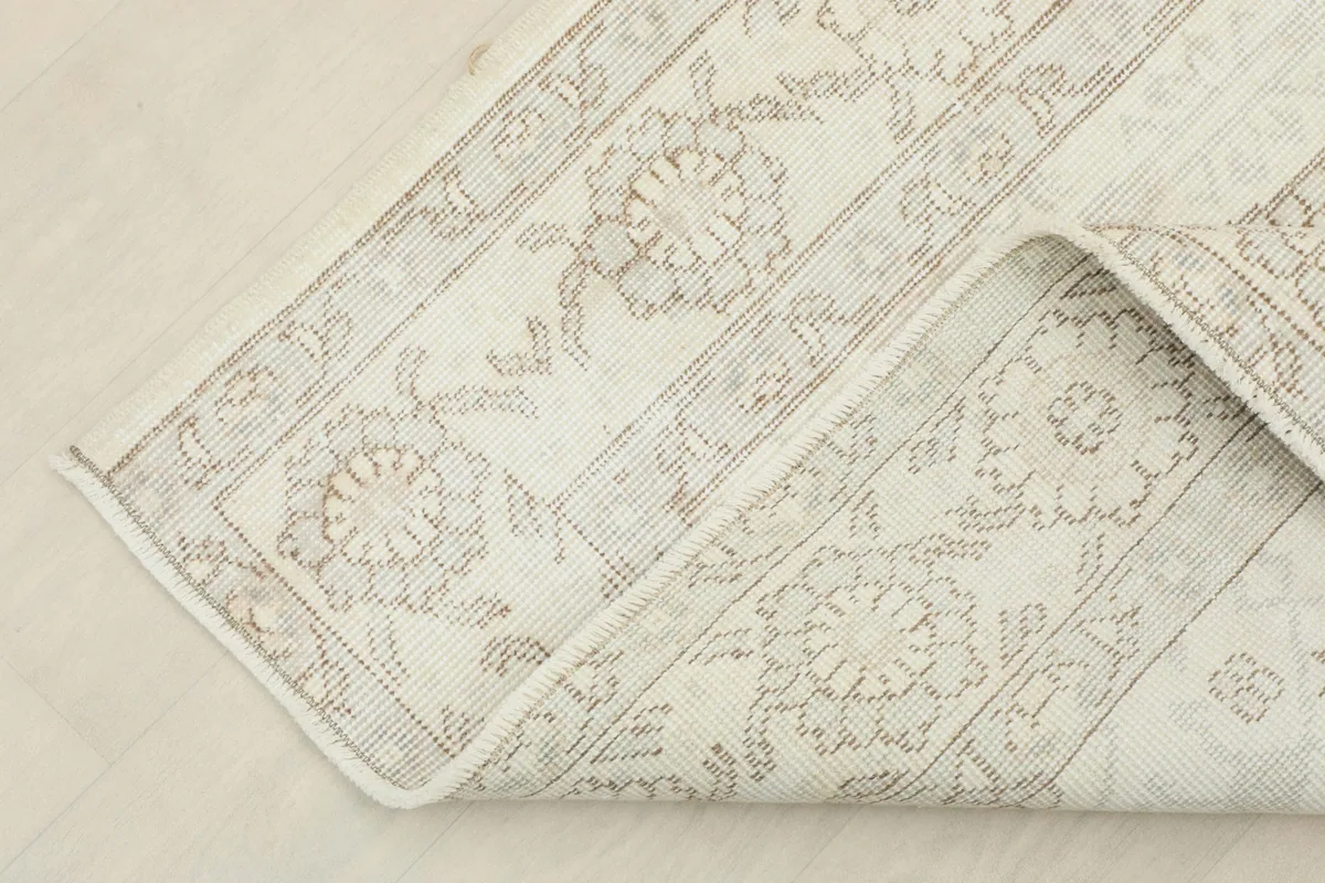 Corner of the rug folded to show the thickness and texture of the vintage wool pile.