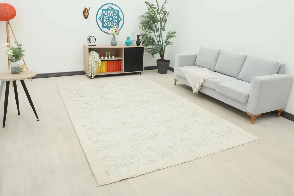 Ivory and tan floral vintage area rug displayed in a modern living room setting with a light gray sofa.