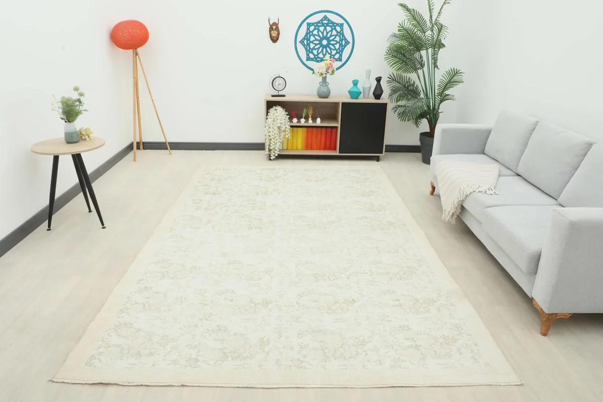 Wide shot of the ivory and tan floral vintage area rug in a living room, providing a full perspective of its size and effect.