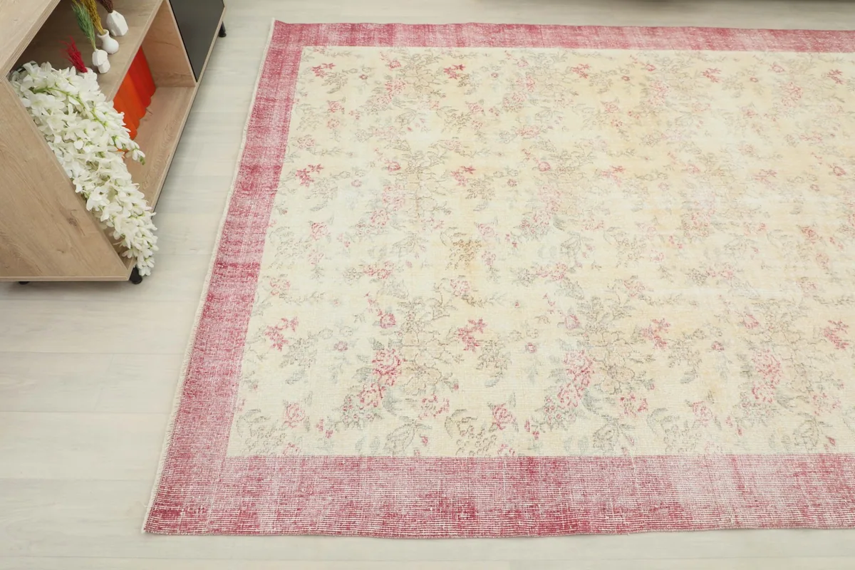 Overhead angle of the rug showing the floral motifs and distressed rose border