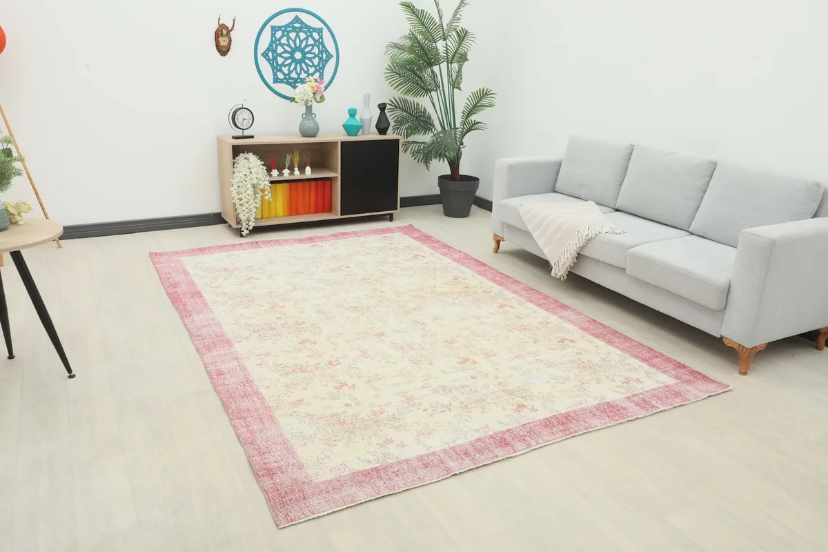 Vintage area rug displayed in a bright living room setting with a light gray sofa