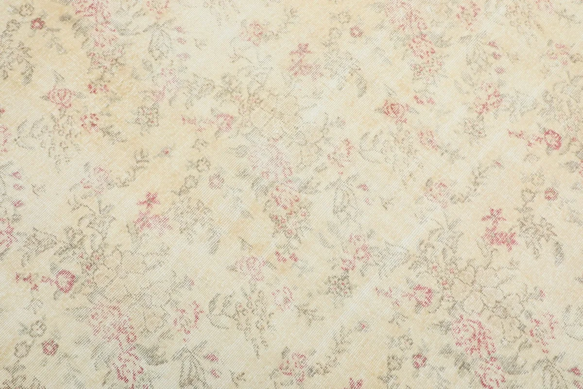 Close-up detail of the ivory field with subtle rose and olive floral patterns
