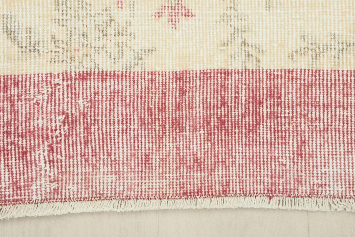 Close-up of the distressed rose border and fringes of the Anatolian rug