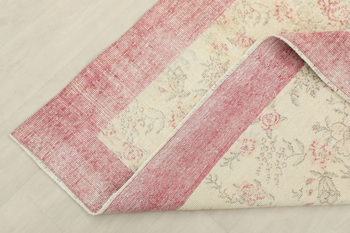 Corner of the rug folded back, showing the cotton foundation and reverse side