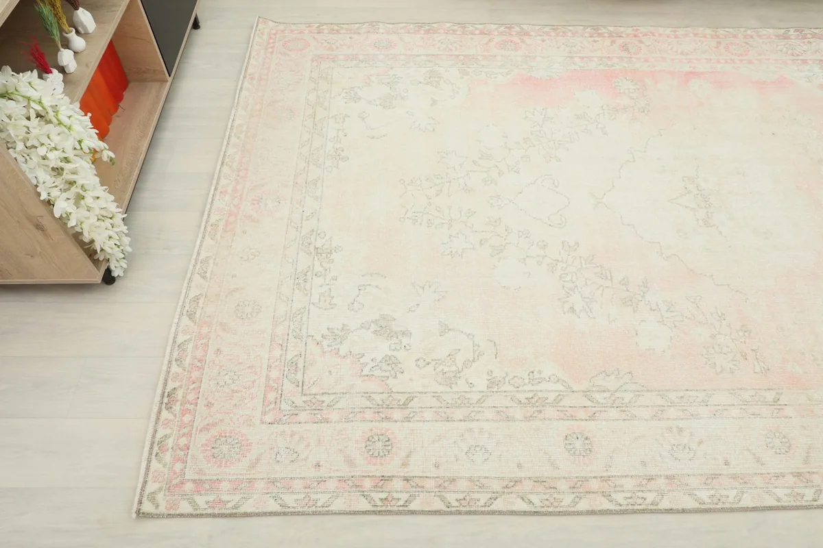 View of the rug's surface and border from an angle, showing the subtle color variations and hand-knotted texture.