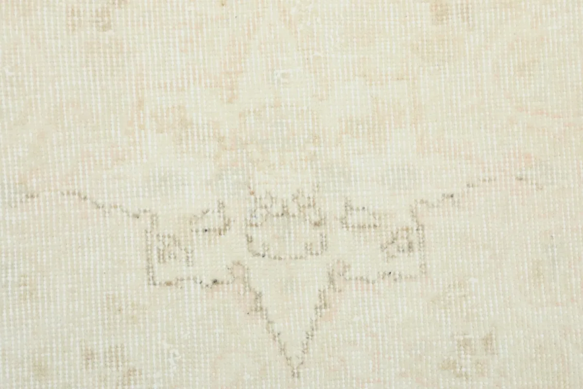 Close-up of the central area of the rug, showing the wool pile and the intricate, faded medallion design.