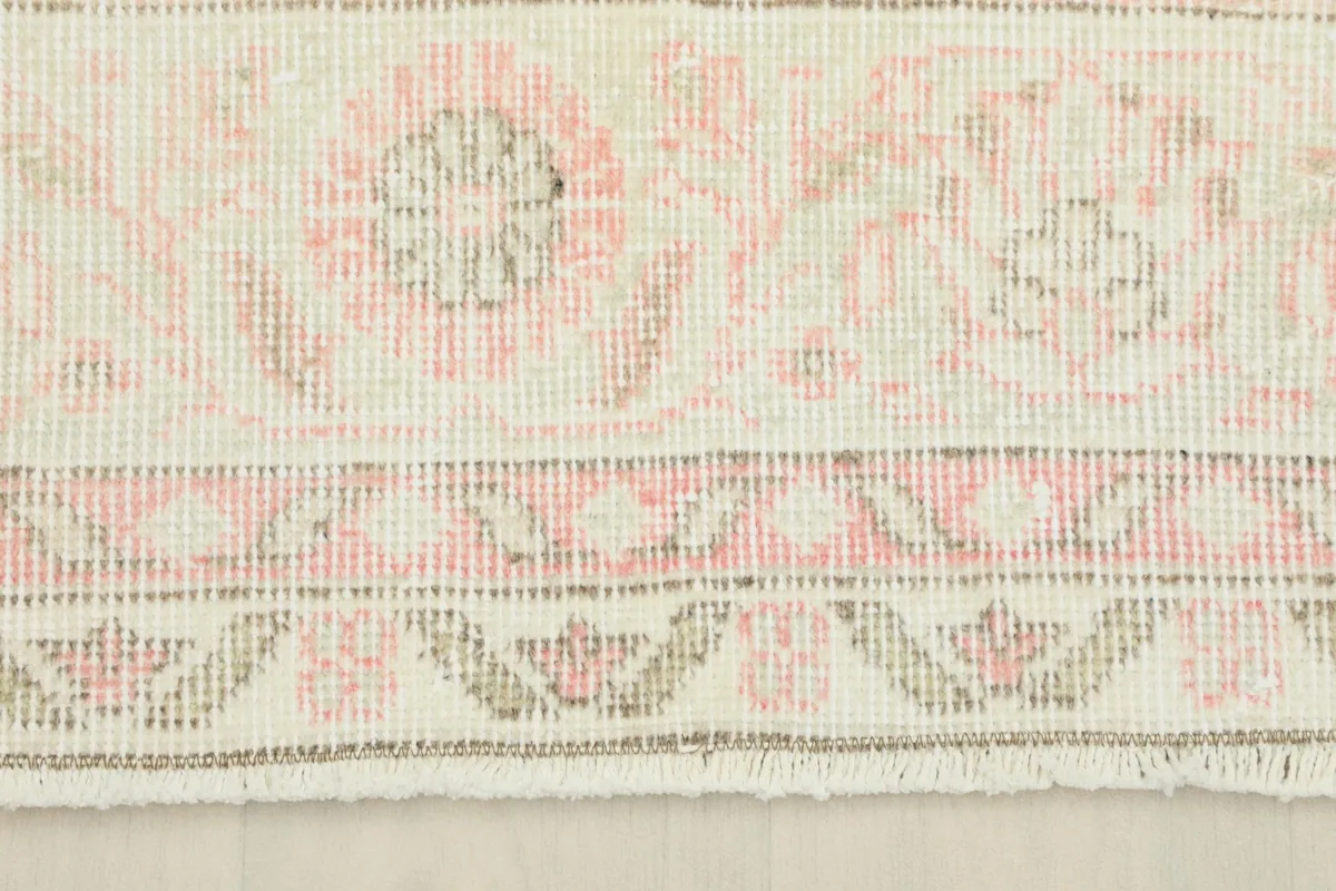 Detailed view of the rug's border and fringe, showing the hand-knotted wool pile and cotton foundation.