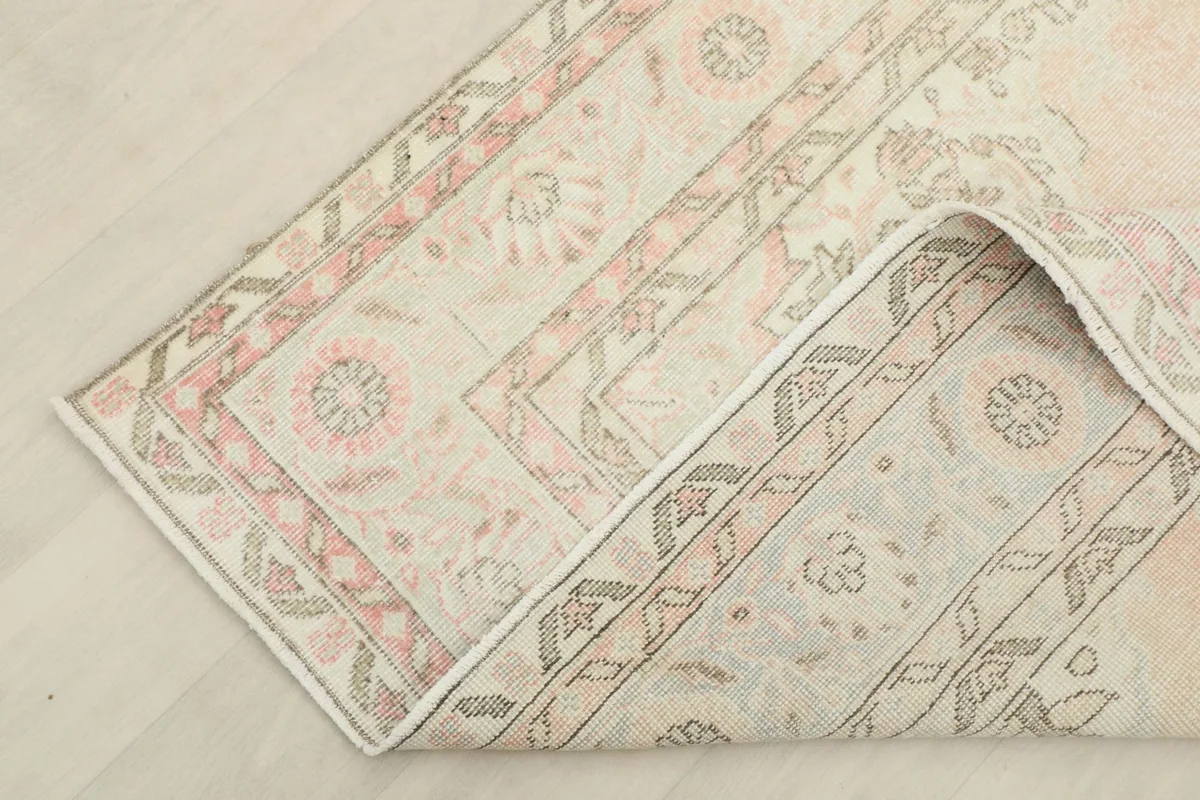 Corner of the rug folded back, displaying the reverse side and the quality of the hand-knotting.