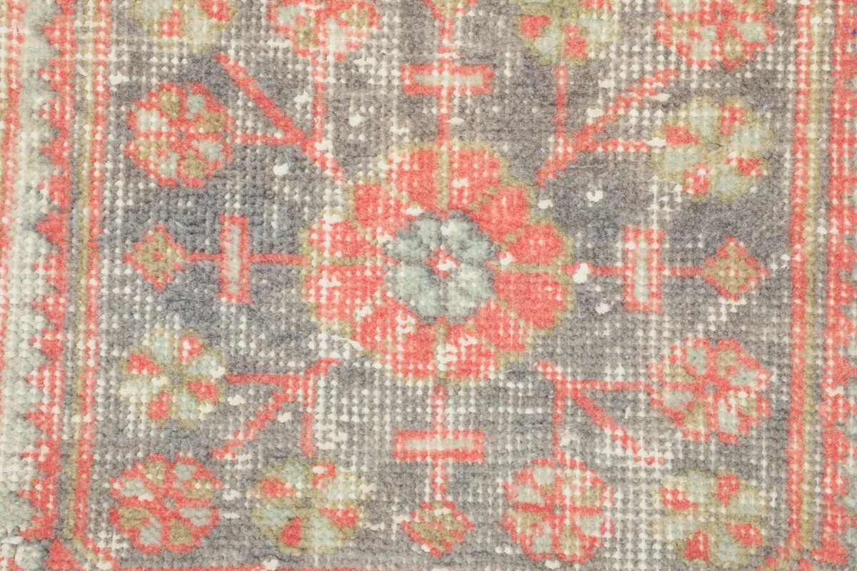 Macro shot of a dark geometric motif, showing the intricate knotting and color variations.