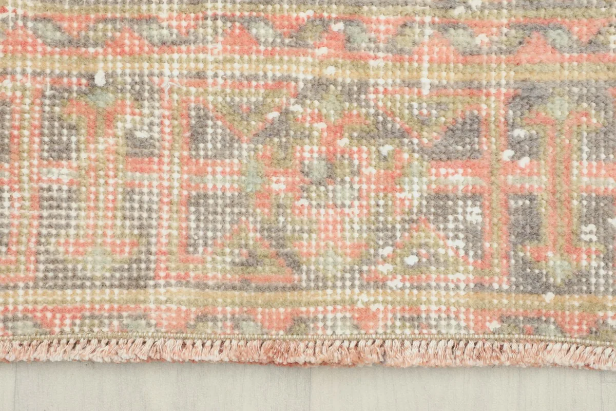 Close-up of the rug's border and short fringe, revealing the hand-knotted texture.