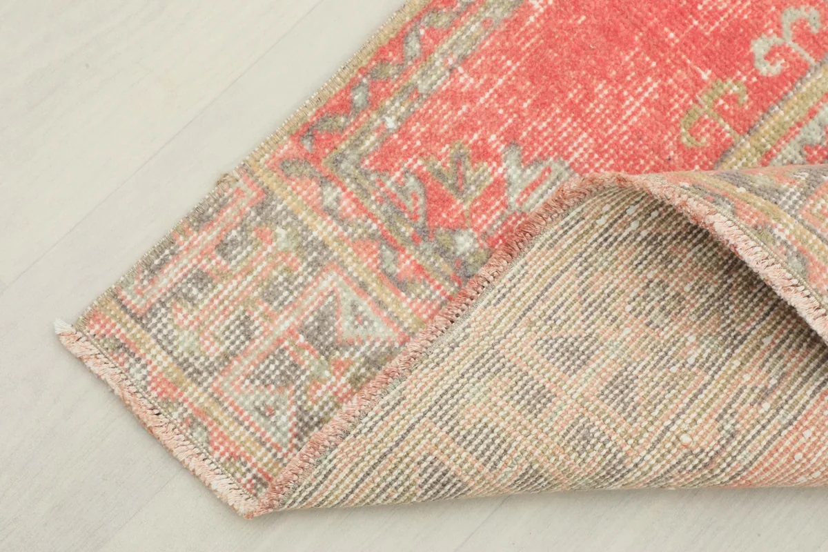 Corner of the rug folded to reveal the back, showcasing the tightly woven cotton foundation.