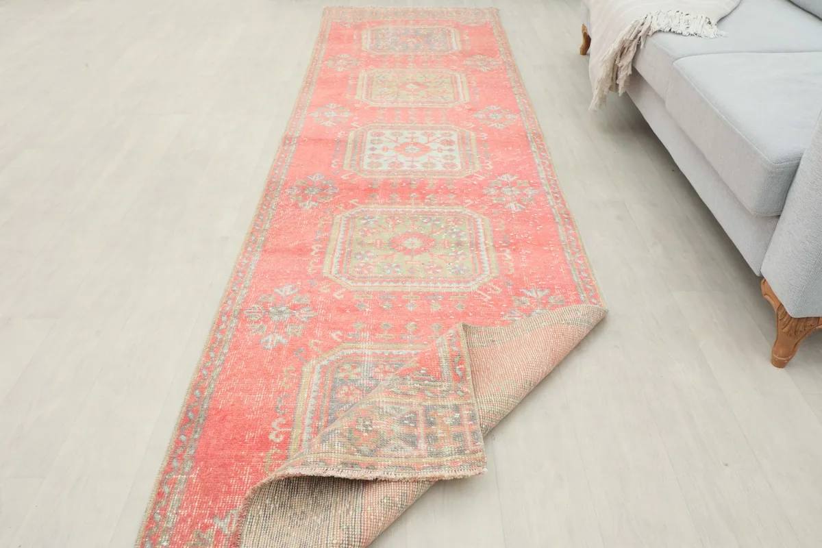 The rug partially folded back, showing the cotton foundation and the reverse side.