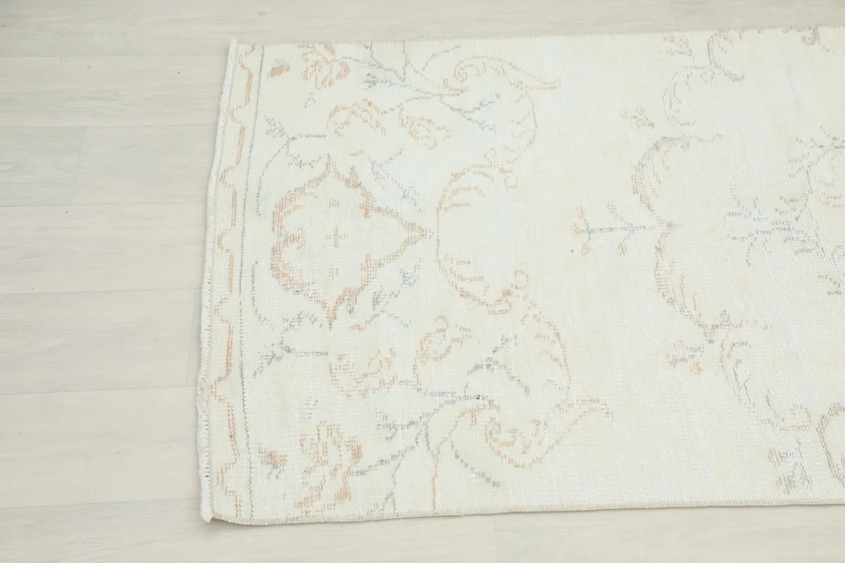 Detailed angled view highlighting the faded floral and geometric motifs near the edge of the runner.