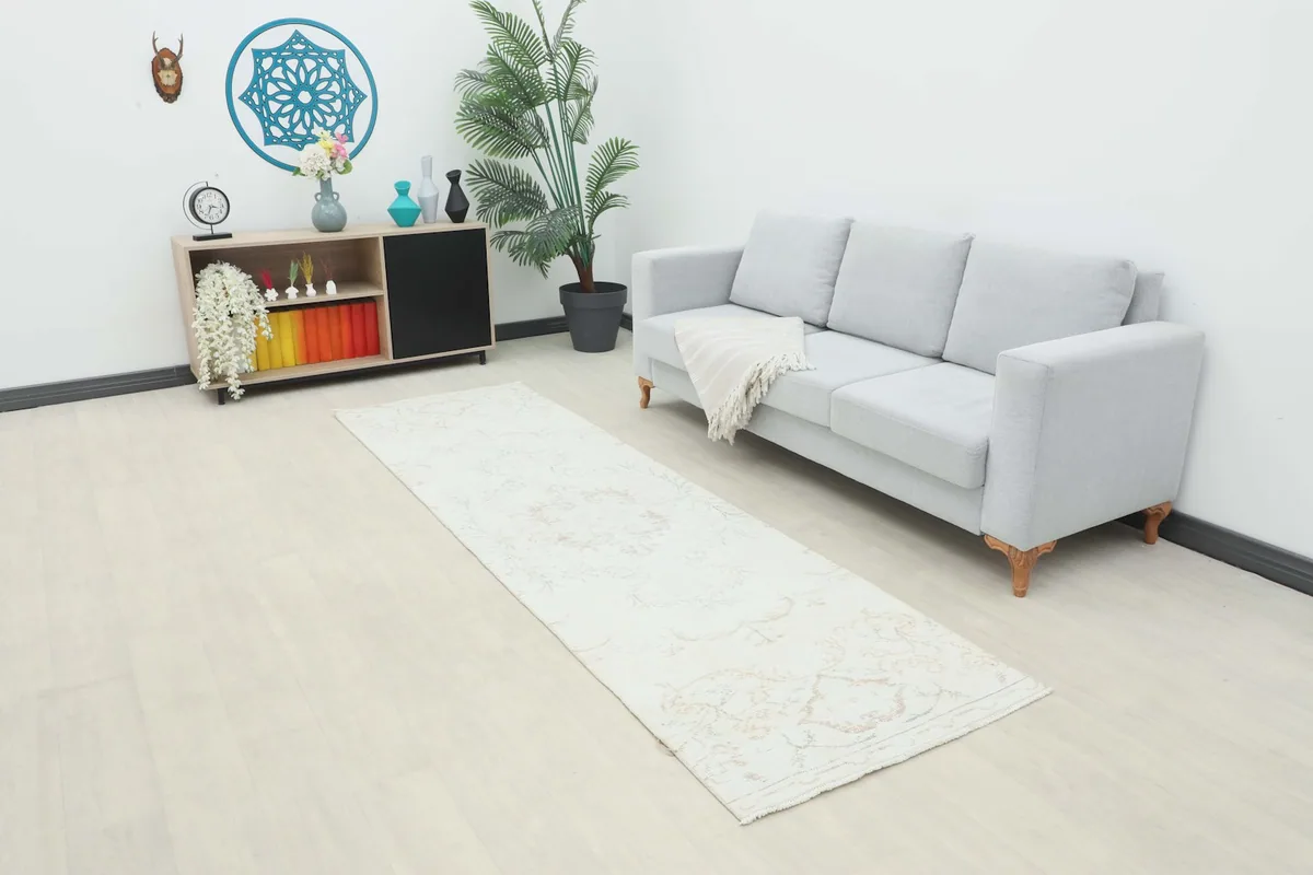 Long view of the ivory beige runner rug placed in a modern living room setting.
