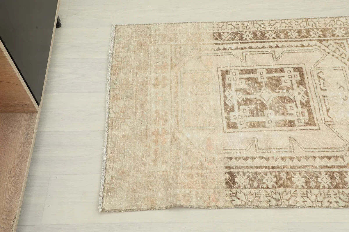 Overhead angle shot of the runner rug's end, revealing its vintage patina and color variation.