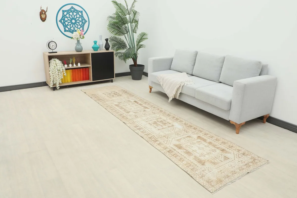 Vintage Anatolian runner rug extending across a room with a sofa, showing its length and scale.