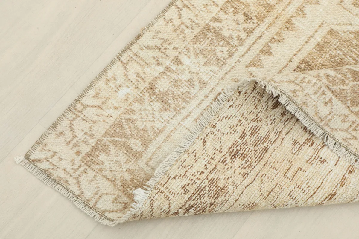 View of the underside of the runner rug, showing the cotton foundation and hand-knotted construction.
