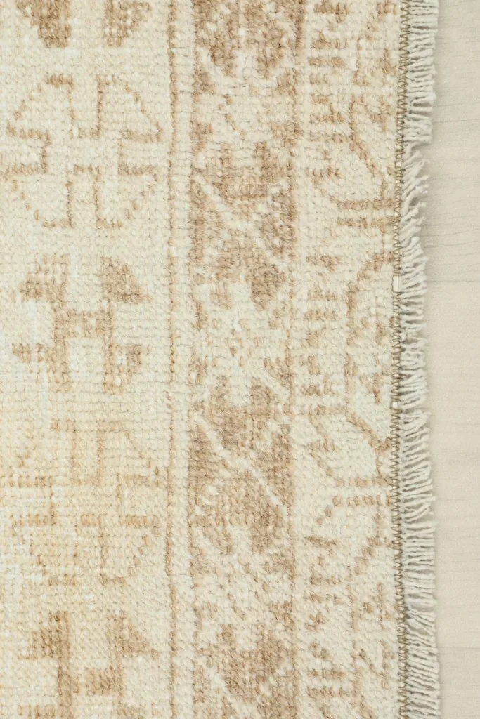 Close-up of the short, natural fringe at the end of the runner rug, alongside the geometric border.