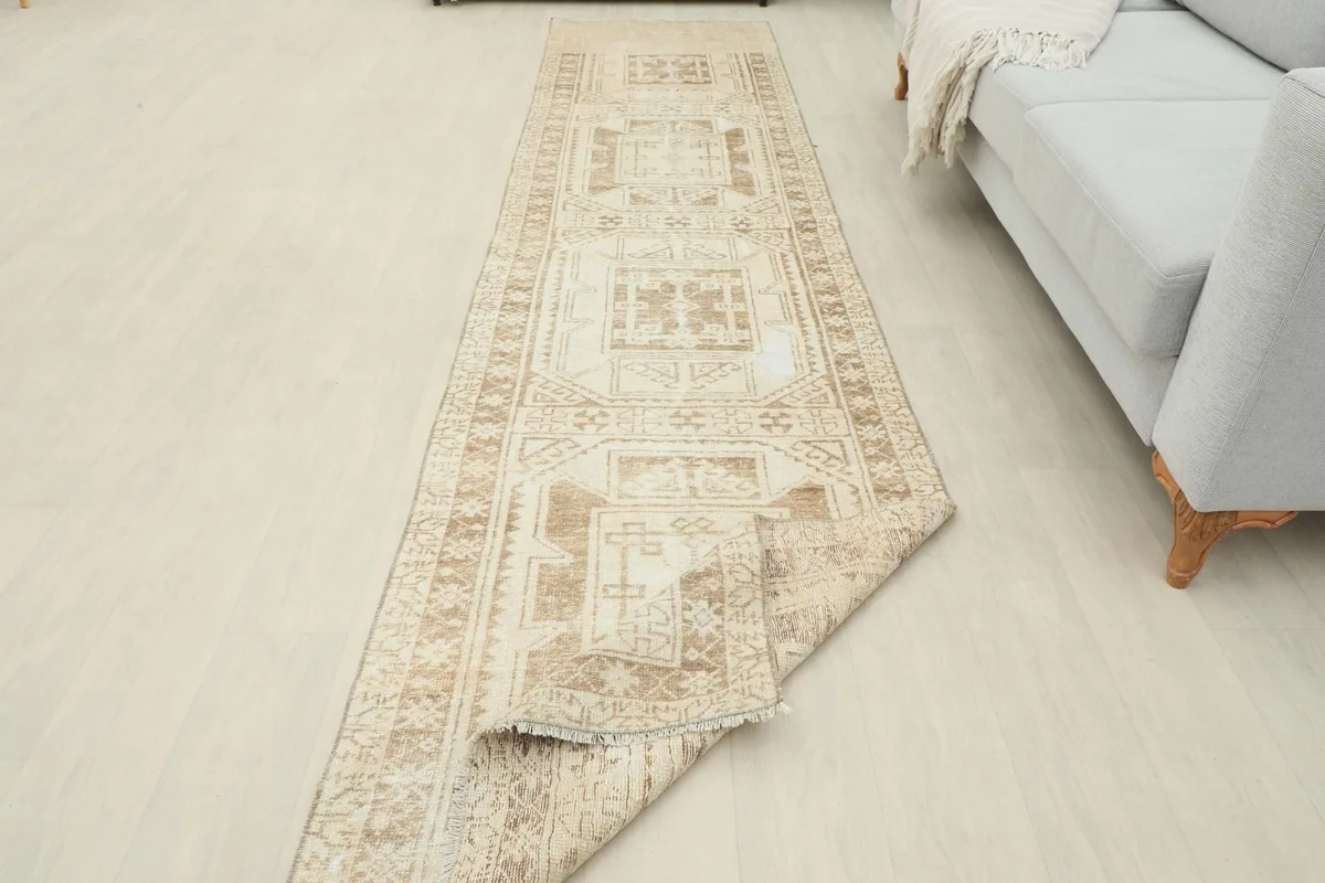 The runner rug partially folded, demonstrating its flexibility and the overall length in a room setting.