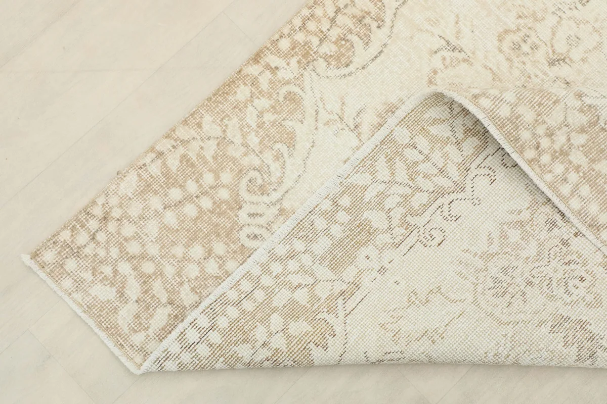 Corner of the rug folded to show the hand-knotted construction and cotton foundation