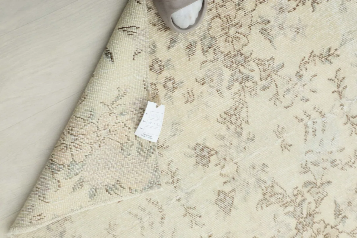 Back of the rug with a tag, showing the intricate knotting on the cotton foundation