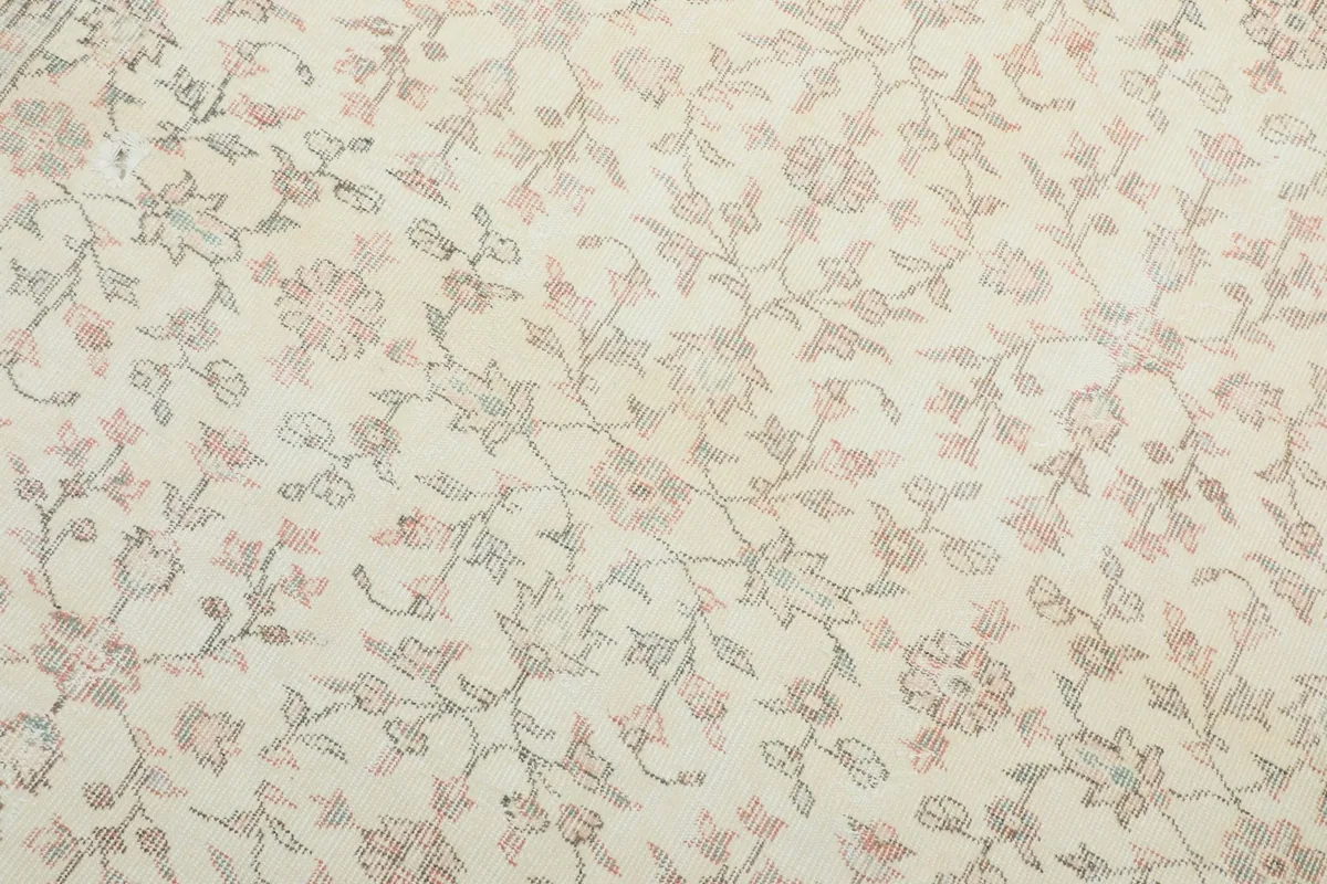 Detailed view of the intricate rose and green floral patterns on the ivory field
